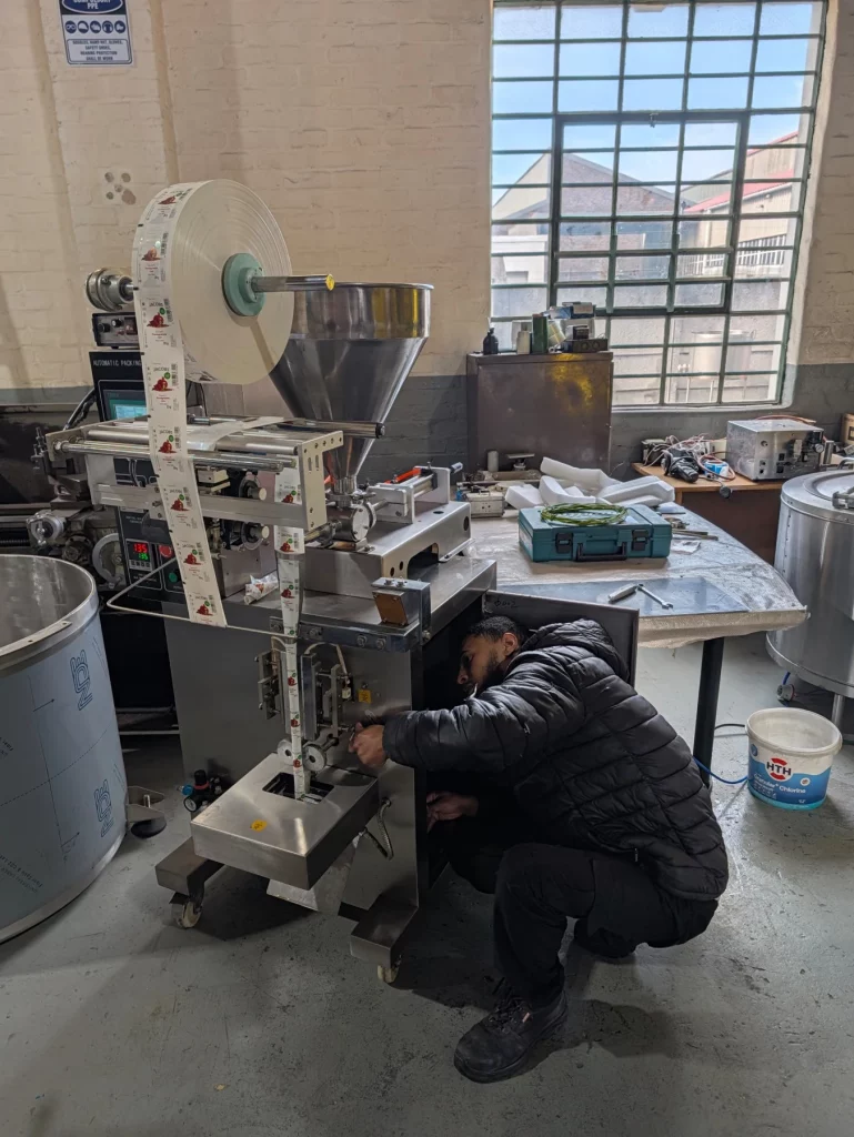 Technician working on a sachet filling and sealing machine in the Process Equipment workshop
